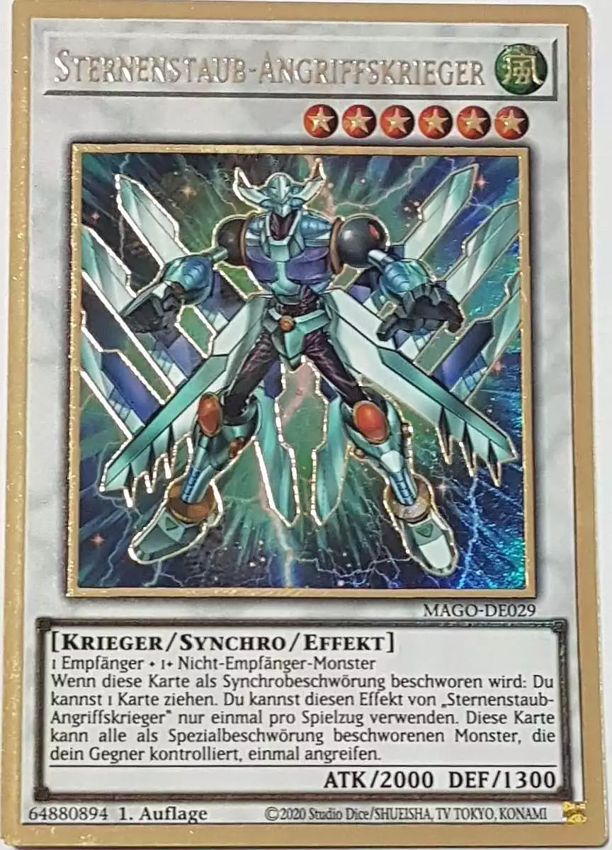 Sternenstaub-Angriffskrieger MAGO-DE029 ist in Premium Gold Rare Yu-Gi-Oh Karte aus Maximum Gold 1. Auflage