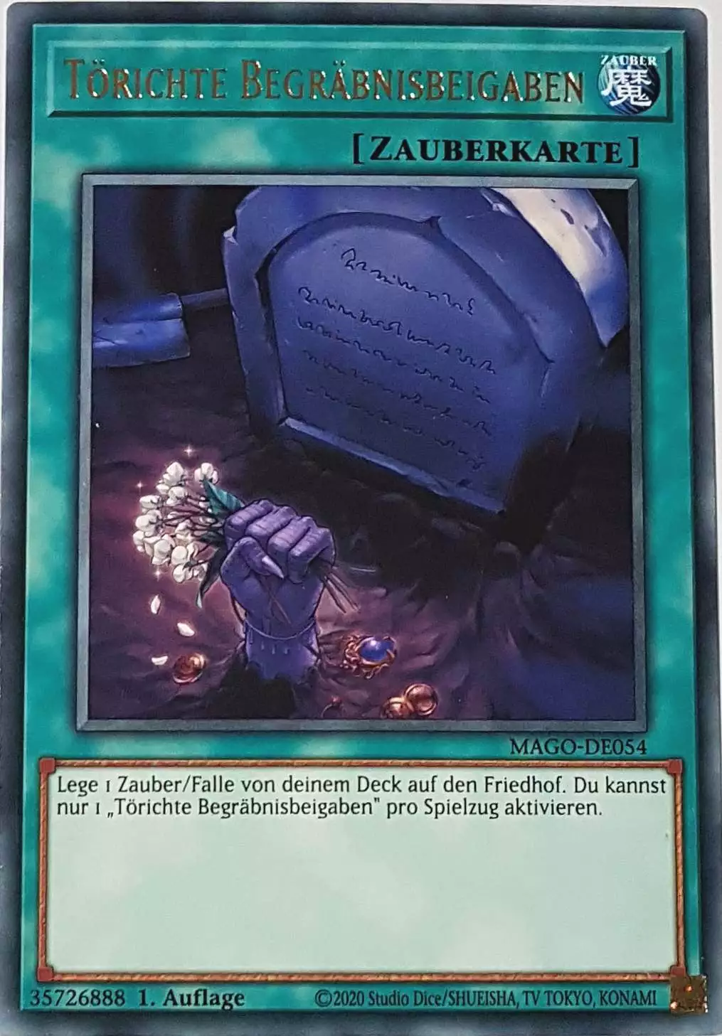 Törichte Begräbnisbeigaben MAGO-DE054 ist in Gold Rare Yu-Gi-Oh Karte aus Maximum Gold 1. Auflage