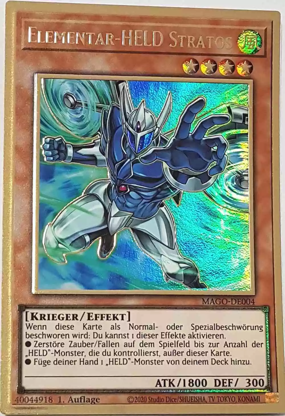 Elementar-HELD Stratos (alternativ art) MAGO-DE004 ist in Premium Gold Rare Yu-Gi-Oh Karte aus Maximum Gold 1. Auflage