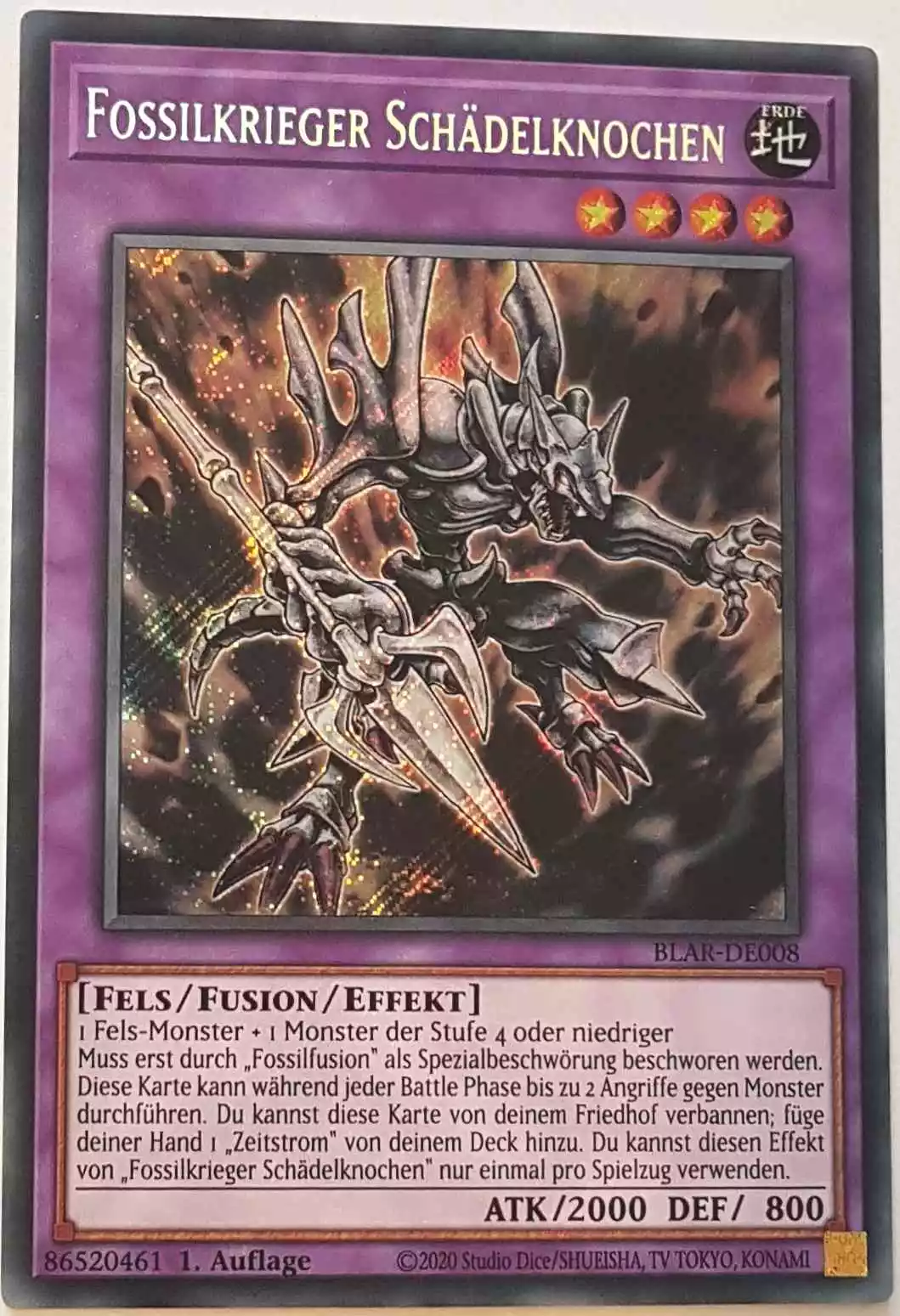 Fossilkrieger Schädelknochen BLAR-DE008 ist in Secret Rare Yu-Gi-Oh Karte aus Battles of Legend: Armageddon 1.Auflage